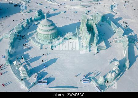 (240104) -- HARBIN, 4 gennaio 2024 (Xinhua) -- questa foto aerea scattata il 26 dicembre 2023 mostra i turisti che si divertono all'Harbin Ice-Snow World di Harbin, nella provincia di Heilongjiang nel nord-est della Cina. La provincia di Heilongjiang ha abbondanti risorse di ghiaccio e neve, rendendola una destinazione popolare per il turismo invernale in Cina e attirando numerosi turisti dalla patria e dall'estero durante le vacanze di Capodanno. "Città di ghiaccio" Harbin, la capitale della provincia di Heilongjiang, ha accolto quasi 3,05 milioni di visitatori, rastrellando 5,91 miliardi di yuan (circa 832,39 milioni di dollari) di entrate turistiche, durante le vacanze, W Foto Stock