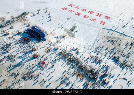 (240104) -- HARBIN, 4 gennaio 2024 (Xinhua) -- questa foto aerea mostra un festival di raccolta di ghiaccio sul fiume Songhua a Harbin, capitale della provincia di Heilongjiang nella Cina nord-orientale, 7 dicembre 2023. La provincia di Heilongjiang ha abbondanti risorse di ghiaccio e neve, rendendola una destinazione popolare per il turismo invernale in Cina e attirando numerosi turisti dalla patria e dall'estero durante le vacanze di Capodanno. La "città di ghiaccio" Harbin, la capitale della provincia di Heilongjiang, ha accolto quasi 3,05 milioni di visitatori, rastrellando 5,91 miliardi di yuan (circa 832,39 milioni di dollari) di entrate turistiche, durante la festa Foto Stock