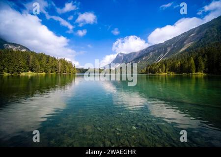 Vista sulla superficie del Lago di Tovel, la scogliera rocciosa del Monte Corno in lontananza. Foto Stock