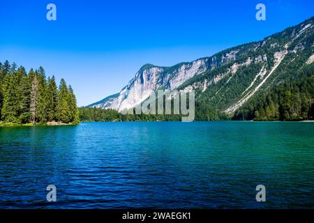 Vista sulla superficie del Lago di Tovel, la scogliera rocciosa del Monte Corno in lontananza. Foto Stock