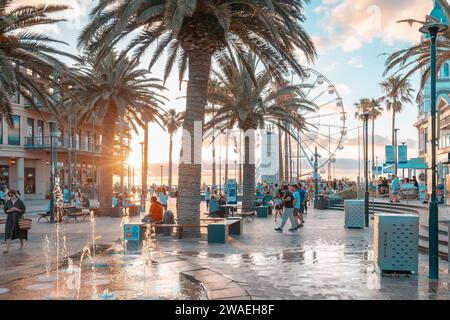 Adelaide, Australia - 2 gennaio 2013: L'iconica Moseley Square a Glenelg con persone al tramonto. Potrai vedere il Pioneer Memorial e la ruota panoramica gigante Foto Stock