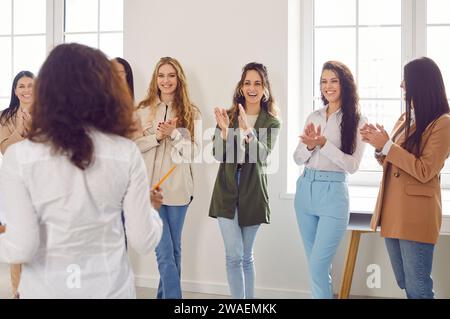 Donne e colleghi felici che applaudono a una riunione che celebra il successo o i risultati aziendali. Foto Stock