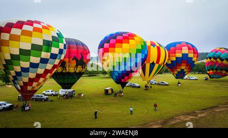 Una colorata esposizione di palloncini in varie forme e dimensioni, con un gruppo di persone riunite in primo piano Foto Stock