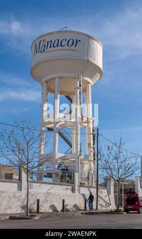 Manacor, Spagna; 02 gennaio 2024: Serbatoio d'acqua gigante e fontana per riempire bottiglie d'acqua con persone che riempiono bottiglie, nella città di Manacor Foto Stock