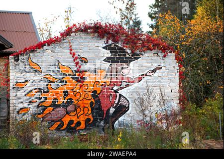 Un primo piano di un murale dipinto che adorna il lato di un muro di mattoni rossi a Bauska, Lettonia Foto Stock