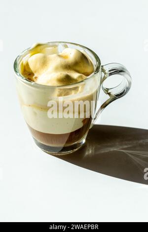Una piccola tazza di espresso con gelato alla vaniglia su un tavolo bianco Foto Stock
