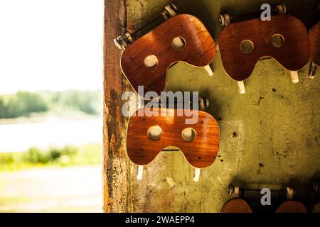 Una collezione di sedili vintage per barche a remi in legno appesi a una parete con una finitura invecchiata e resistente agli agenti atmosferici Foto Stock