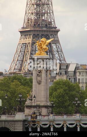 La base della Torre Eiffel si erge su un lussureggiante paesaggio di alberi verdi a Parigi, in Francia Foto Stock