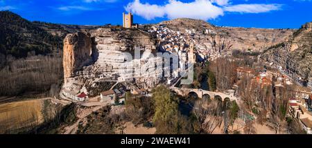 Spagna, Alcala de Jucar - pittoresco villaggio medievale situato tra le rocce. Vista panoramica dall'alto del drone aereo con il castello e il ponte Foto Stock