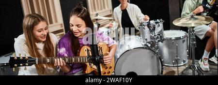 concentrati sulle ragazze adolescenti che suonano la chitarra e cantano vicino ai loro amici sfocati, banner Foto Stock