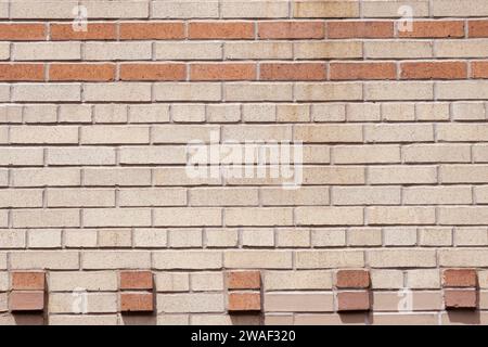 parete decorativa in mattoni con motivo geometrico bicolore in terracotta e sfondo beige in stile art deco Foto Stock