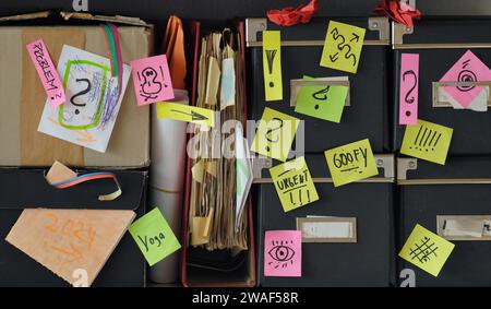 Scaffale disordinato con cartelle di file, appunti, vecchie carte e scatole di storage.nastro rosso, burocrazia, aminizzazione, ufficio disordinato e concetto di business caotico. Foto Stock