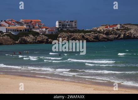 Sport acquatici sulla costa di fronte alle case storiche della penisola di Baleal (Peniche, Portogallo) Foto Stock