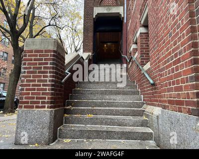 Un edificio in mattoni rossi con una scala che porta all'entrata Foto Stock