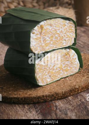 Tempeh crudo avvolto in foglie di banana, cibo tradizionale indonesiano, creato con soia Foto Stock