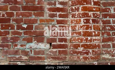 frammento di un muro di mattoni con sporgenza semicircolare fatto di mattoni rossi con macchie di vernice bianca, parte della facciata di un vecchio edificio in mattoni Foto Stock