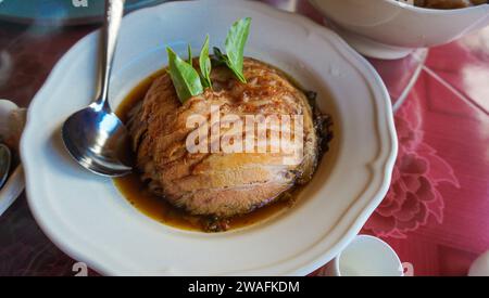 Nocciolo di maiale con foglie di tè dello Yunnan. Noci di maiale tailandese con cibo tradizionale. Cosce di maiale stufata su riso cotto. Famoso Street food in Thailandia Foto Stock