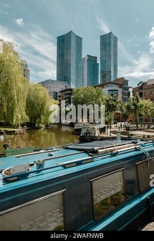 Un gruppo di grattacieli si erge alto sopra il bacino del canale di Manchester. Vita cittadina, alti appartamenti e case galleggianti. Stile di vita, viaggi o turismo. Foto Stock