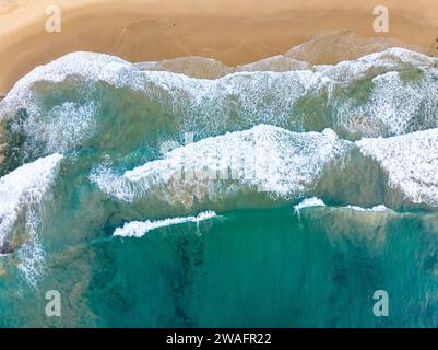 Una vista aerea di una spiaggia tropicale e delle onde blu dell'oceano Foto Stock