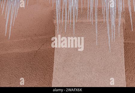 Ghiaccioli sul tetto. Lo scarico è pieno di neve e ghiaccio. Ghiaccio cadere concetto di pericolo. Foto Stock