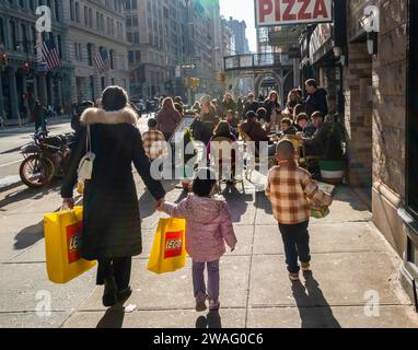 Famiglia con acquisti Lego nel quartiere Flatiron di New York venerdì 29 dicembre 2023. (© Richard B. Levine) Foto Stock