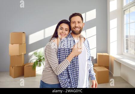 Ritratto di un giovane marito e moglie sorridente e felice nella nuova casa il giorno del trasloco Foto Stock