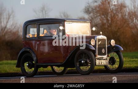 Stony Stratford, Regno Unito, 1 gennaio 2024. Auto Austin Seven 1932 Maroon che arriva a Stony Stratford per l'annuale New Year Day, veicolo d'epoca e classico fes Foto Stock