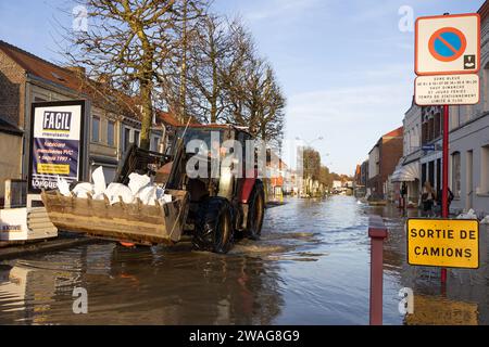 Arques, Francia. 4 gennaio 2024. Un trattore porta sacchi di sabbia nelle strade di Arques la strega ha subito un'alluvione molto significativa, a Pas de Calais, in Francia, il 4 gennaio 2024. Foto di Sebastien Courdji/ABACAPRESS.COM credito: Abaca Press/Alamy Live News Foto Stock