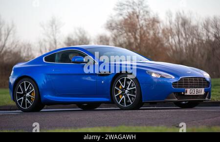 Stony Stratford, Regno Unito 1 gennaio 2024,2015 auto blu Aston Martin Vantage V8 in arrivo a Stony Stratford per l'annuale Capodanno in stile vintage e classico Foto Stock