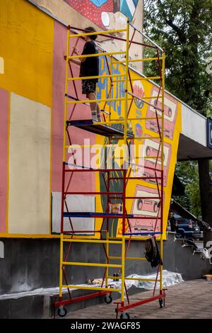Artista che crea un murale su un edificio ad Almaty, Kazakistan Foto Stock