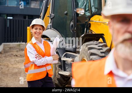 Team di appaltatori di progetto che ispezionano il cantiere Foto Stock