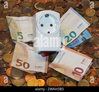 presa e denaro, immagine simbolo costi dell'elettricità Foto Stock