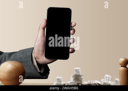 La mano dell'uomo d'affari mostra una schermata vuota del telefono cellulare con un simbolo della tariffa. Schermo del telefono cellulare vuoto per spazio di copia. Concetto di investimento finanziario Foto Stock