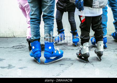 Le persone che si alzano sui pattini di ghiaccio nell'arena di pattinaggio della città si godono il freddo invernale Foto Stock