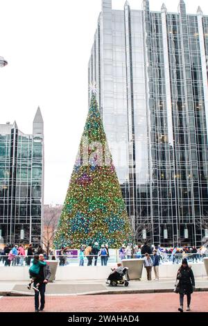 Le persone si riuniscono all'esterno della pista di pattinaggio su ghiaccio PPG Arena per guardare i pattinatori con gli alti grattacieli riflettenti sullo sfondo a Pittsburgh, Pennsylvania Foto Stock