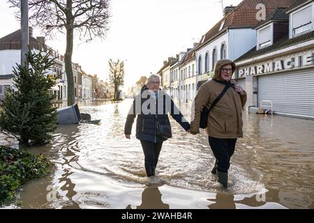 Pas De Calais. 5 gennaio 2024. La gente cammina su una strada allagata nella città di Arques, Pas-de-Calais, Francia settentrionale, 4 gennaio 2024. I vigili del fuoco francesi nel dipartimento francese settentrionale del Pas-de-Calais hanno salvato giovedì 59 persone in più da inondazioni causate da condizioni meteorologiche estreme, portando il numero totale di soccorritori a 710 dal 30 dicembre 2023, la prefettura locale ha annunciato giovedì sera. Secondo la prefettura di Pas-de-Calais, circa 189 comuni e 2.016 famiglie sono attualmente colpiti dall'aumento del livello dell'acqua nel dipartimento. Crediti: Franck Duval/Xinhua/Alamy Live News Foto Stock