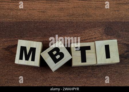 Concetto di cubi di legno con la parola MBTI su sfondo di legno. Foto Stock