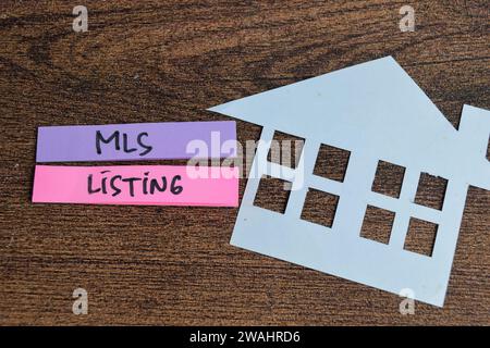 Concetto di MLS Listing scrivere su note appiccicose isolate su tavola di legno. Foto Stock