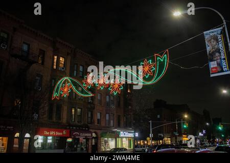 Una città trafficata, con auto che percorrono una strada illuminata dalle luci festive di New York, Stati Uniti Foto Stock
