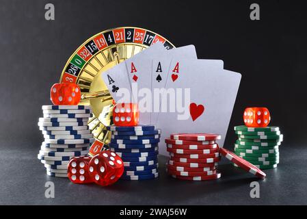 Lo sfondo dei giochi del casinò è isolato sul tavolo nero con carte da gioco, chip da gioco, dadi e roulette per giocare a vari giochi d'azzardo. Vista frontale. Foto Stock