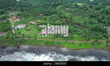 Questa foto aerea di un remoto paesaggio tropicale offre una vista mozzafiato di un fiume tortuoso e di antichi e pittoreschi edifici Foto Stock