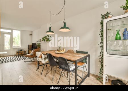 Tavolo e sedie in legno nella moderna sala da pranzo di una lussuosa casa con soggiorno sullo sfondo Foto Stock