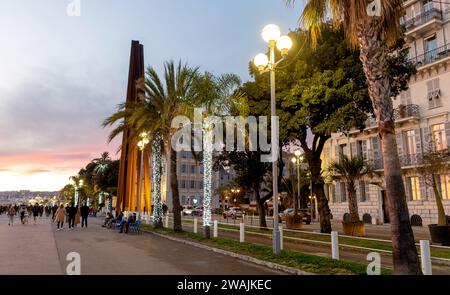 Gente che cammina lungo la Promenade Des Anglais di notte Nizza Francia Foto Stock