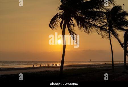 Taqah, salalah- 12 dicembre 2023: Persone che giocano a calcio in spiaggia al tramonto Foto Stock