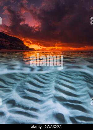 Vista di Spalato con tramonto luminoso e fondo marino sabbioso sottomarino nell'oceano tropicale. Foto Stock