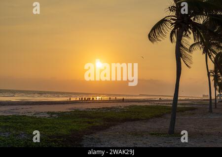 Taqah, salalah- 12 dicembre 2023: Persone che giocano a calcio in spiaggia al tramonto Foto Stock