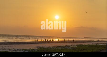 Taqah, salalah- 12 dicembre 2023: Persone che giocano a calcio in spiaggia al tramonto Foto Stock