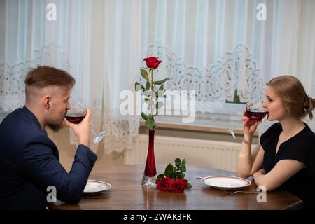La gente beve vino rosso a tavola dopo una cena di famiglia. Foto Stock