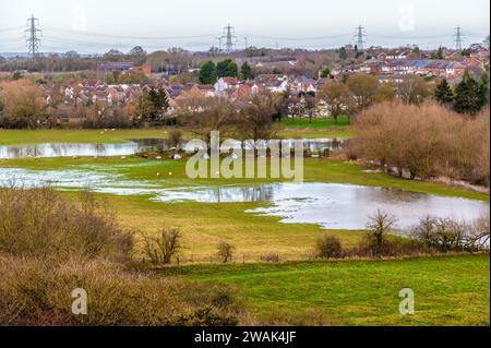 Una vista verso Huncote attraverso i prati d'acqua nel Leicestershire, Regno Unito, in una luminosa giornata di sole Foto Stock