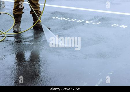 La strada viene spruzzata con acqua pressurizzata per essere pulita, la strada viene lavata con acqua Foto Stock